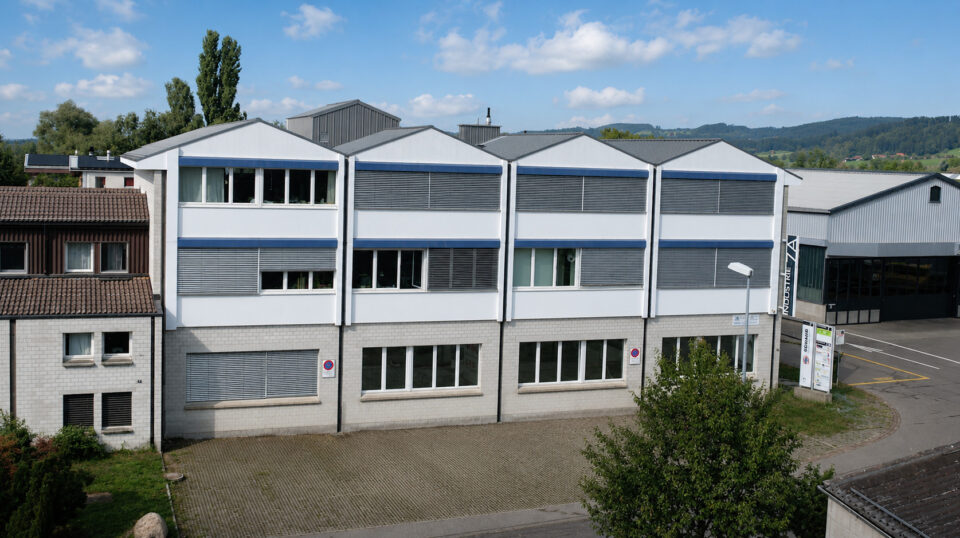 Modernes Industriegebäude mit weißer Fassade und blauen Akzenten