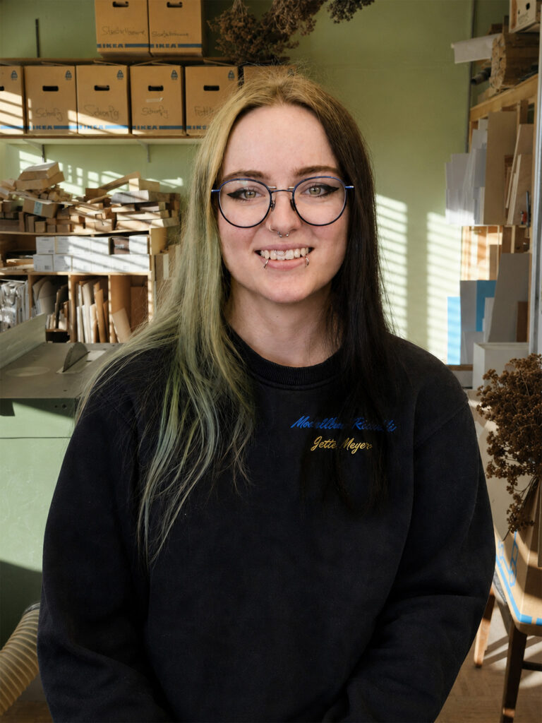 Lächelnde Person mit Brille im Atelier