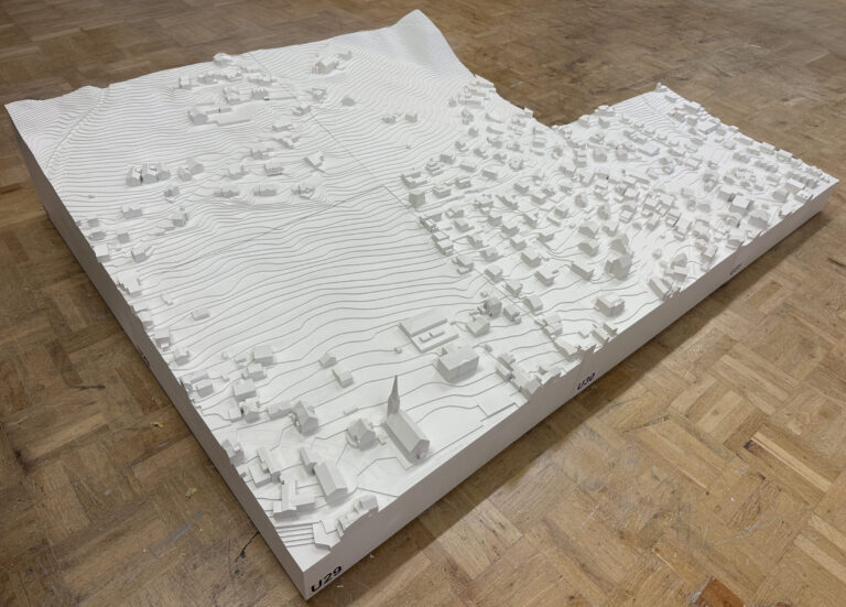 Weißes topografisches Stadtmodell mit Höhenlinien und Gebäuden