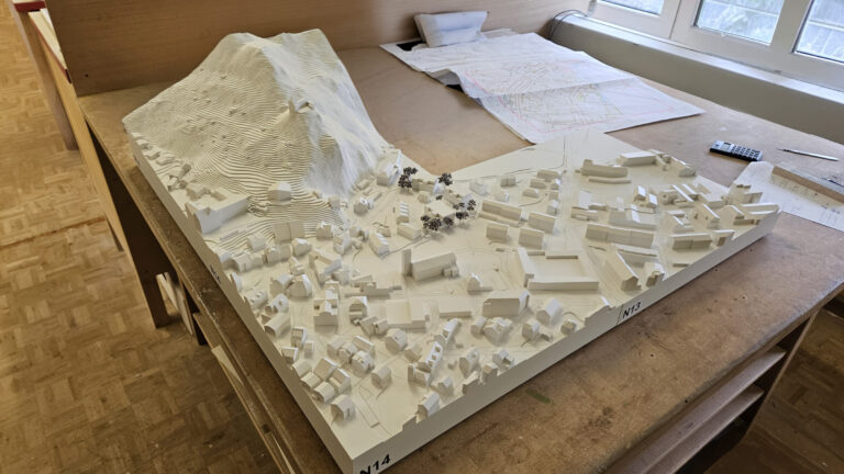 Architekturmodell einer Stadt mit Hügel auf Tisch