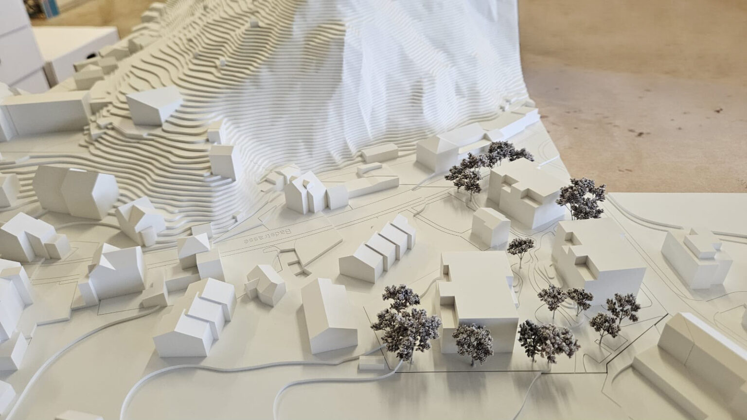 Architekturmodell eines Hügeldorfes mit Häusern und Bäumen