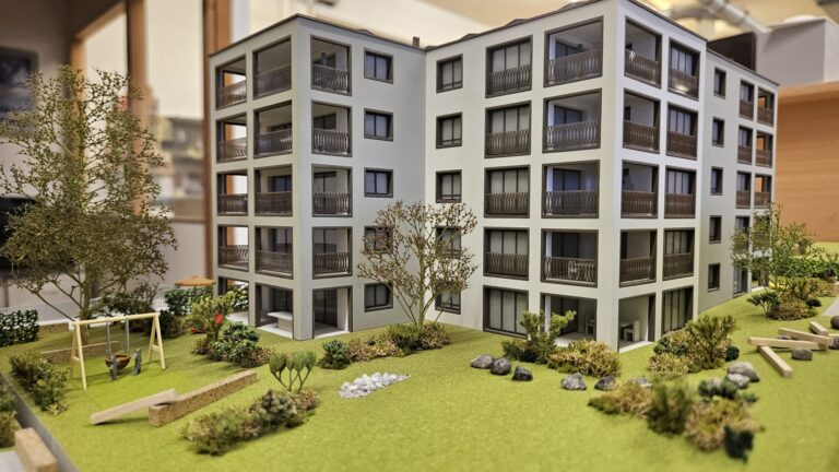 Architekturmodell eines modernen Mehrfamilienhauses mit Garten