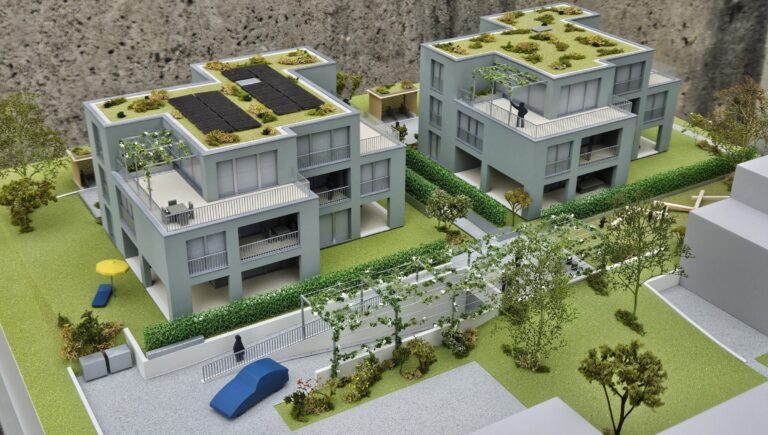 Modell moderner Wohnhäuser mit Gründach und Solaranlagen